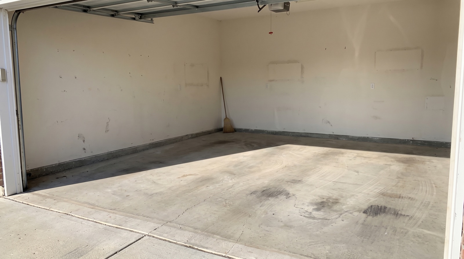Illustrative AI-generated image of an emptied garage with a swept concrete floor and light through the open door — not a TM Junk Removal job